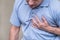 Heart pain, a person grabbing the heart area with his hand, suffering from chest pain, having a heart attack or painful cramps,