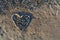 Heart of pebbles on the golden and soft sand