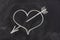 Heart pierced by arrow, love symbol on blackboard