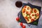 Heart pizza with mozzarella and tomatoes on slate with wine, top view. Valentine`s day date food concept