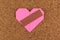 Heart with plaster on corkboard background