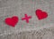 Heart plus heart. Two red toy hearts on burlap background, lovers together and forever concept