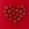 Heart of red candy hearts on deep red paper background. Valentine day card.