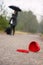 Heart on the road and woman with luggage and umbrella in the background