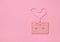 Heart shape from audio cassette tape on pink paper background, top view. Hipster Love