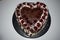 Heart shape cake. Poppy cream cake with white topping and cherry on top, product photography for patisserie. Chocolate, sugar.