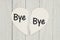 Heart-shape card on weathered wood background with text Bye Bye