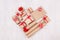 Heart shape of christmas presents of craft paper gifts with red ribbons and bows on soft light white wood board, flat lay.