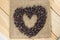 Heart shape coffee beams on sackcloth wood background.