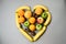 Heart shape of Colorful fresh fruit on Gray table. Orange, banana, apples, kiwi, grapefruit. Flat lay, top view. Fruit background.