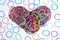 Heart shape of colorful rubber ring on white paper background