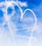 Heart shape with cupids arrow written in the sky with smoke