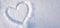 Heart shape drawn on snow closeup, Valentine day background