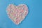 Heart shape figure from colored marshmallow on blue background