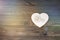 A heart shape with gears on a wooden background.