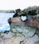 Heart shape geological formation naturally occurring in lava rock wall at Nakalele in Hawaii, USA