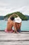 Heart shape, hands and couple by ocean while on a summer, romantic and tropical vacation. Island, dock and back of man