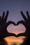 Heart shape hands at dusk silhouette sunset sky