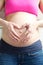 Heart shape with hands in front of pregnant stomach