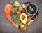 Heart shape of ketogenic low carbs diet concept. Ingredients for healthy foods selection on dark stone background. Balanced