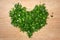 The heart shape is made of chopped green onions, parsley and dill. White isolated background. Vitamins for health