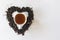 Heart shape made with a mixture of a variety of dried tea leaves and a cup of black tea