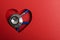 Heart shape made of red paper adn blue stethoscope.Concept of heart health and cardiac diagnostics.Empty space for text