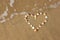 Heart shape made from sea shells on sandy beach. room for text.