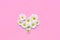 Heart shape made of white Chrysanthemums flowers on soft pink background