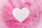 Heart shape on pink glitters on white background