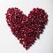 Heart shape pomegranate seeds on white background.  Valentines helthy love concept