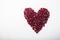 Heart shape pomegranate seeds on white background.  Valentines helthy love concept
