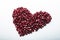 Heart shape pomegranate seeds on white background.  Valentines helthy love concept