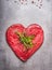 Heart shape raw meat with herbs and text on gray concrete background