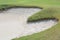 Heart shape sand bunker on beautiful green golf course.