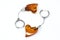 Heart-shaped amber earrings on a silver chain with round earwires handcuffs. On a white background, top view.