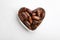 Heart shaped bowl with sweet dried date fruits on white, top view