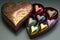 heart-shaped box of assorted chocolates or truffles with foil or cellophane wrapping