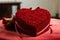 A heart shaped box filled with roses sits elegantly on a table, A heart-shaped gift box covered in red velvet, AI Generated