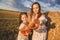 Heart-shaped buns in hands. Mom and her daughter relaxing next to hay bales in summer field