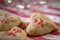 Heart shaped butter spritz cookies with red sugar sprinkles closeup heart bokeh selective focus