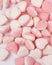 Heart-shaped candy with two different colored sides sprinkled with powdered sugar.