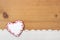 Heart shaped Christmas cookie, crocheted snow on wooden background