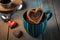 heart-shaped churros in a mug full of warm chocolate sauce