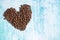 Heart shaped coffee grains on aquamarine background