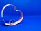 Heart-shaped cookie mold frame. In the center wedding rings. Blue background, isolated, copy space for message. Valentine`s day co
