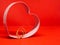 Heart-shaped cookie mold frame. In the center wedding rings. Red background, isolated, copy space for message. Valentine`s day co