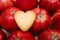 Heart shaped cookie on the red apples