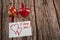 A heart-shaped cookie tied with a ribbon, a hand-sewn textile heart and a note with a Declaration of love on a wooden background.