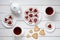 Heart shaped cookies for Valentines day with teapot and two cups of tea on white wooden background.